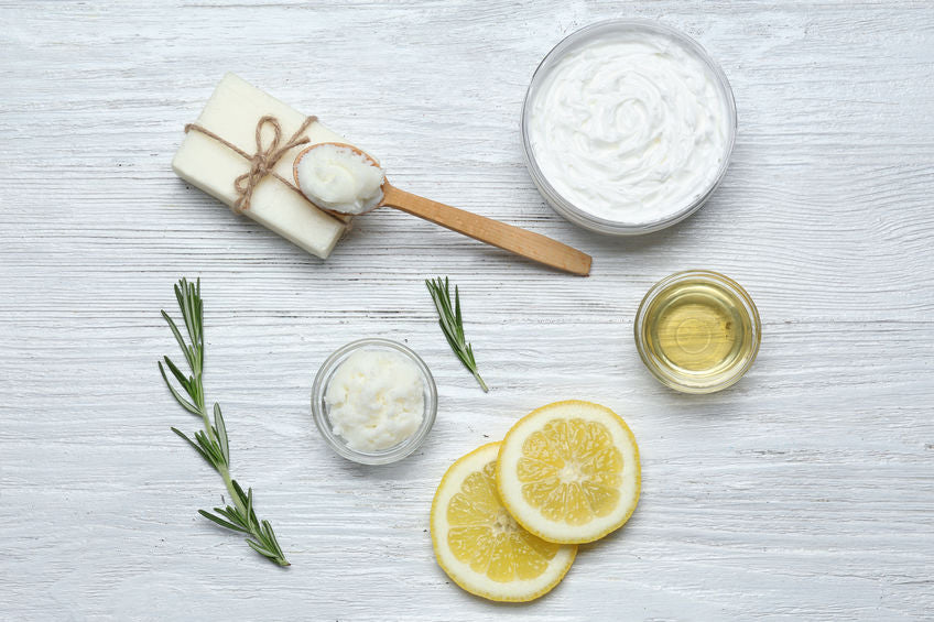 rosemary spring, fresh lemon slices, coconut oil, soap, natural ingredients on table with wooden spoon