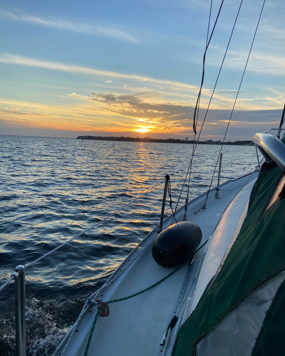 view of sunset over water from sailboat deck